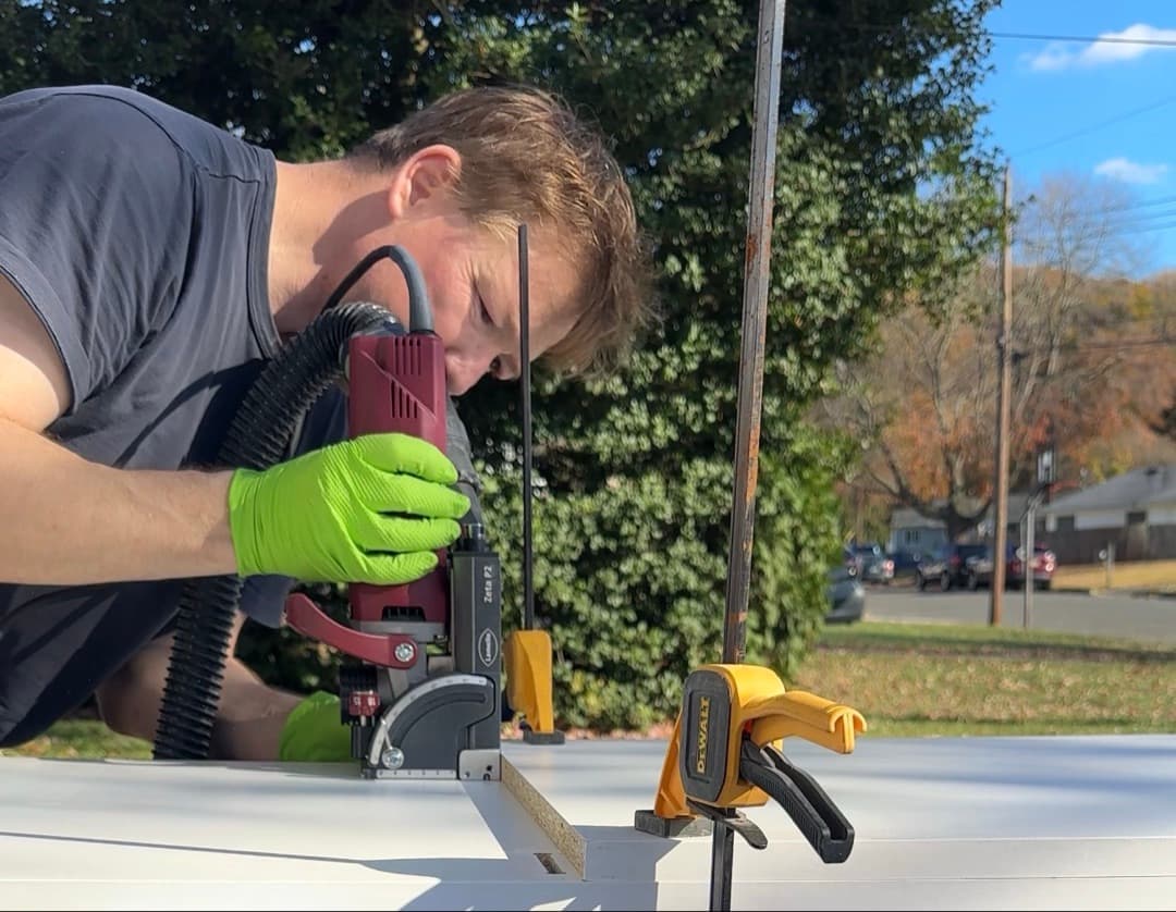 Aaron of Timberdust LLC using a Lamello Zeta P2 biscuit joiner on white melamine panels